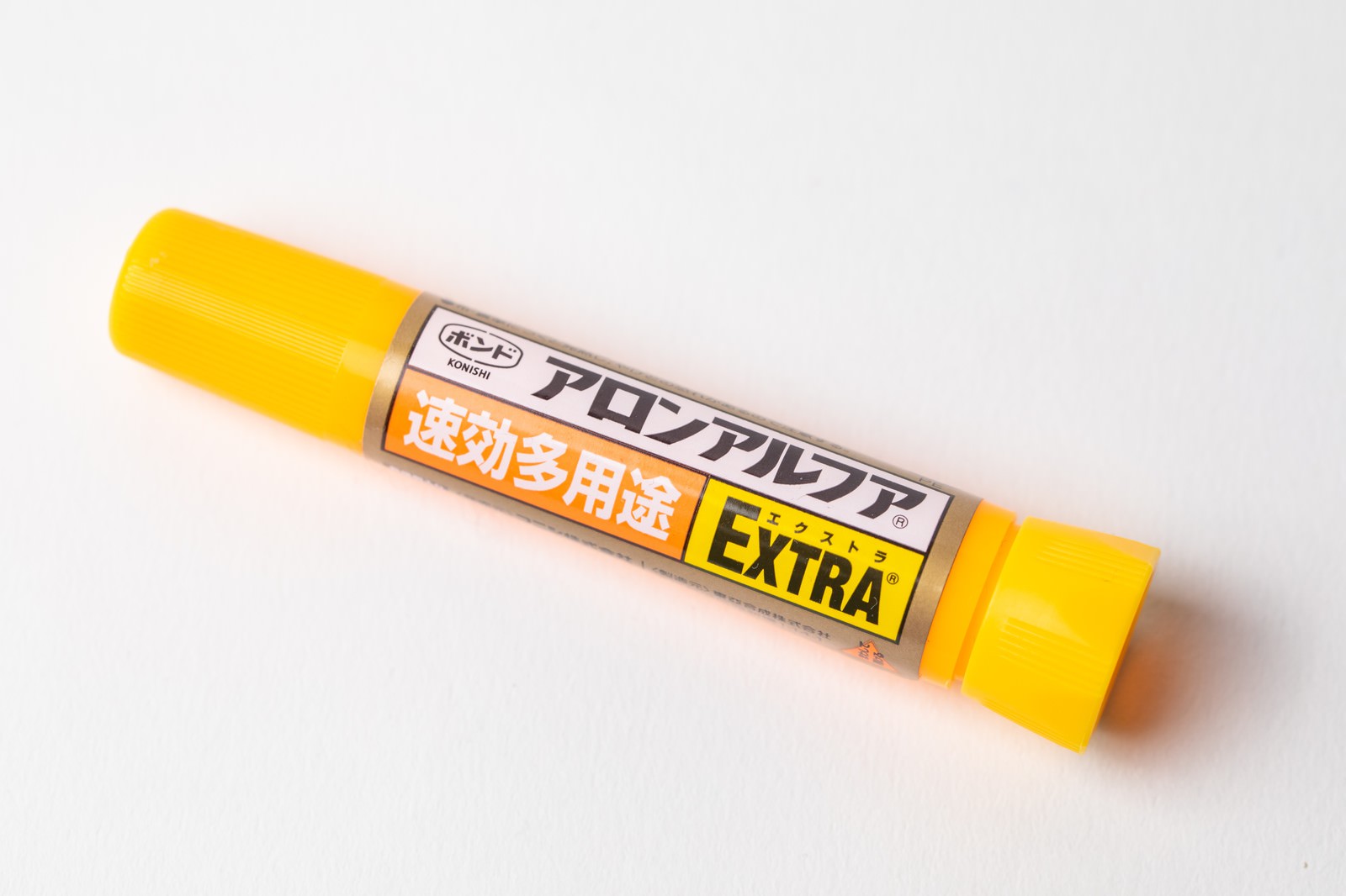 白い背景に置かれた黄色いキャップの瞬間接着剤アロンアルファ