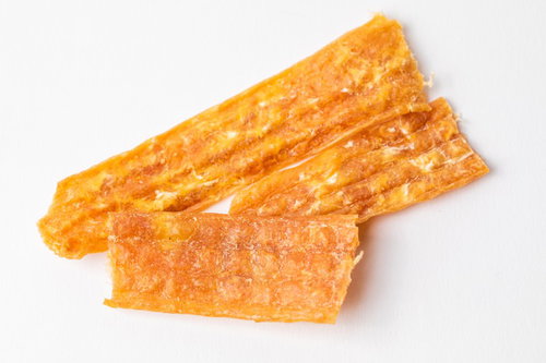 白い背景に並べた犬用の鳥ジャーキー3本、天然鶏肉使用