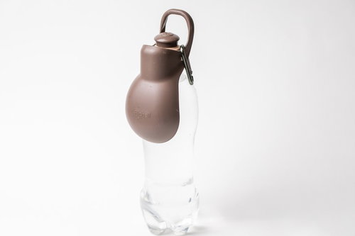 白い背景に置かれたピンク色の犬用お散歩ハンディシャワーボトル