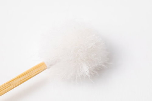 耳かきの木製の柄部分に付いた白い梵天のアップ