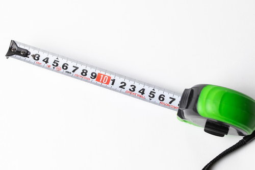 緑色のコンベックスと伸びたメジャーテープ