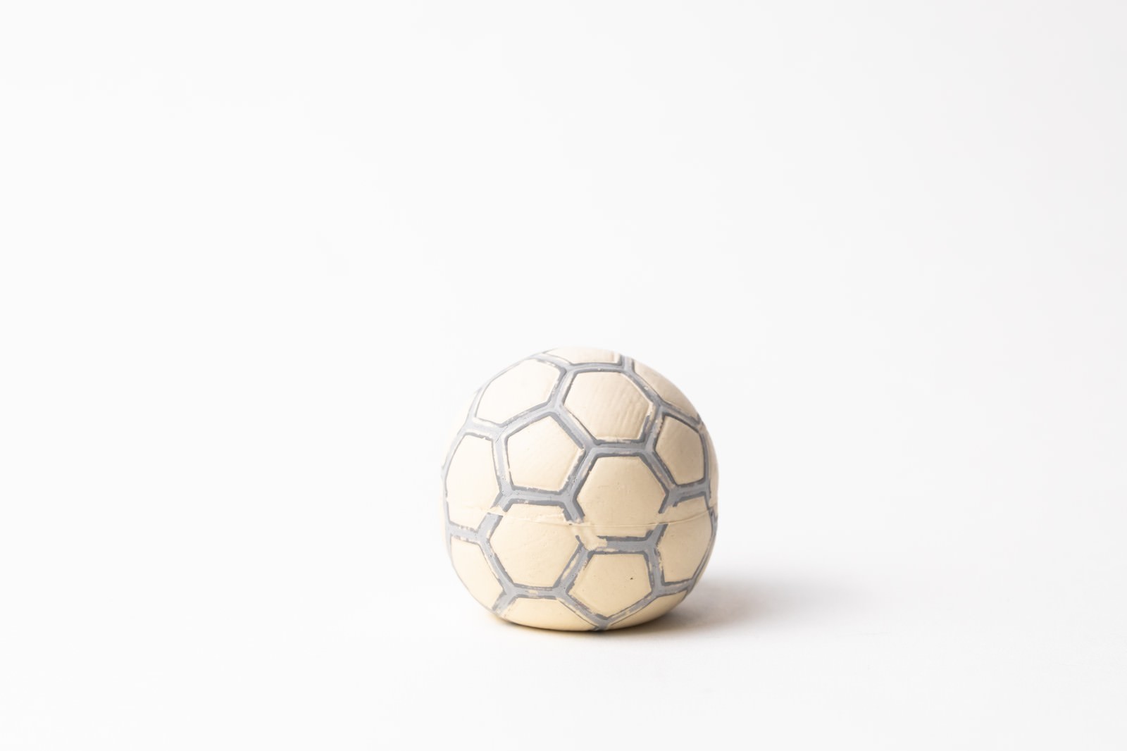白い背景に置かれたサッカーボール型のペット用おもちゃ