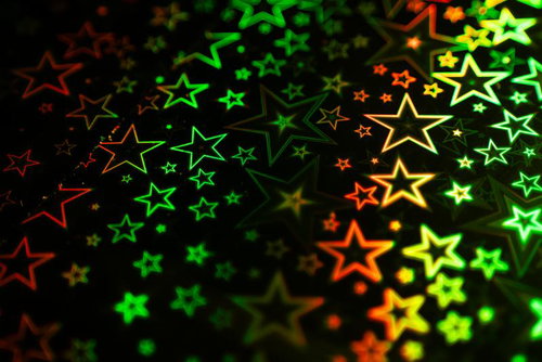 緑とオレンジの星型ホログラフィック背景パターン