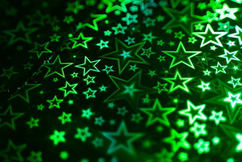 緑色に光る星型パターンのホログラフィック背景