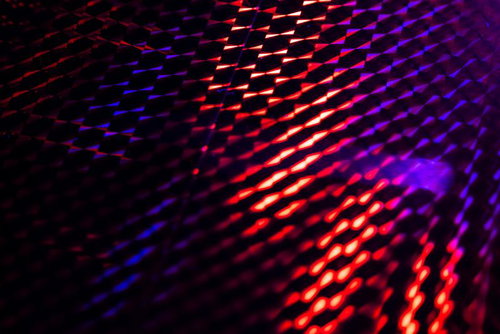 赤と紫のネオン光が斜線状に配列した発光ホログラフィック