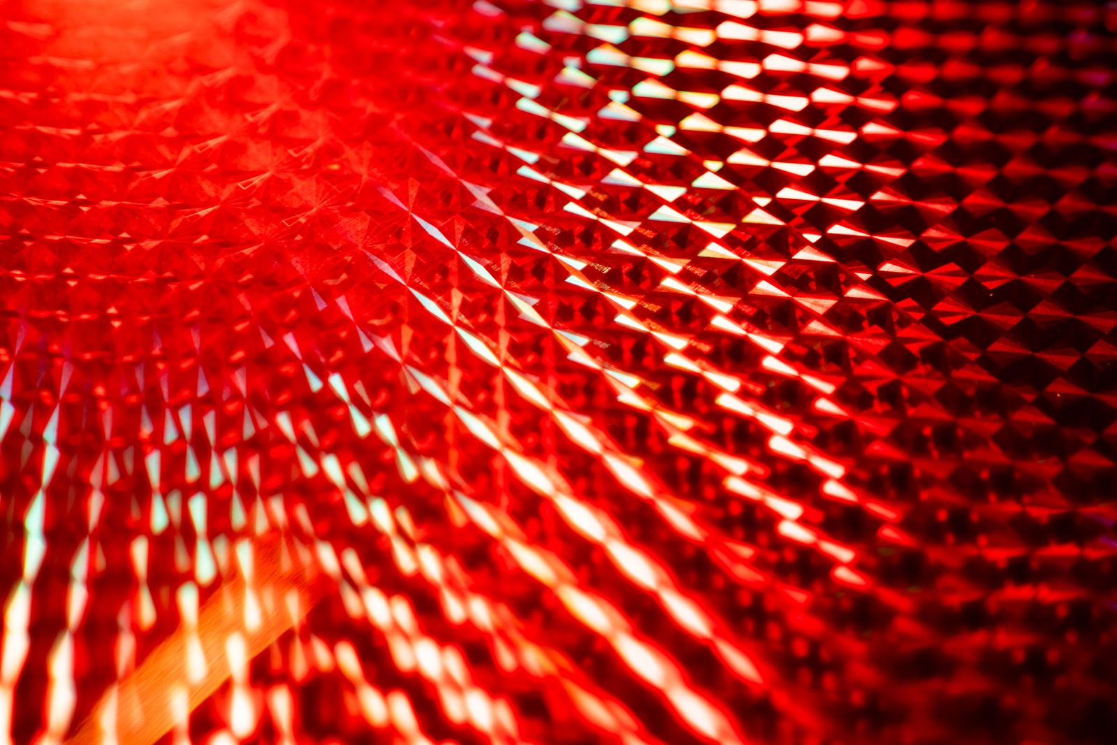 A glittering red LED holographic grid texture.