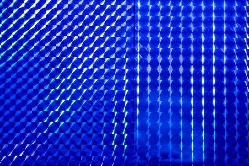 青いホログラム背景に光る幾何学パターンの反射と立体感