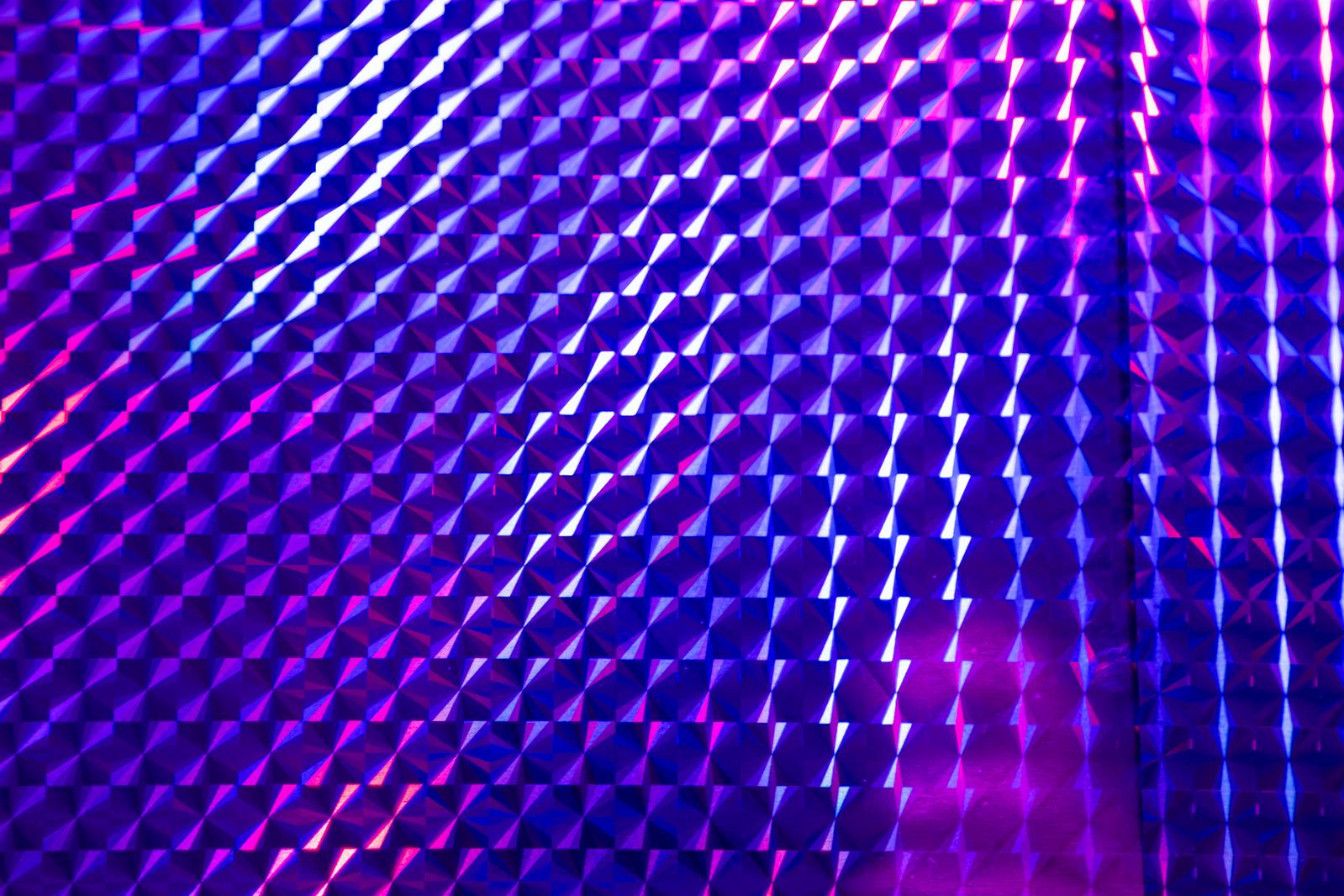 紫とピンク色に発光するネオン菱形パターンの3D立体背景