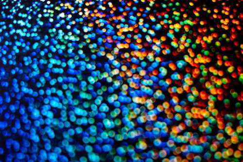 カラフルな光の粒子が輝くホロカード風テクスチャ