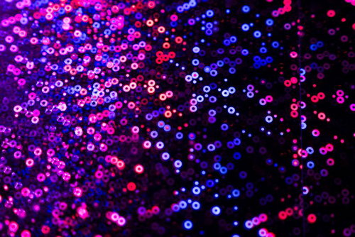 ネオンカラーで発光する球体が浮遊する抽象的なデジタル背景