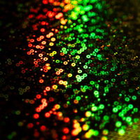 赤から緑へグラデーションする無数のキラキラした円形ボケの光の写真