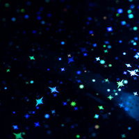 黒い背景に青と緑にきらめく星とキラキラパーティクルの写真
