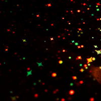 赤と緑の星形エフェクトが散らばるホログラム背景の写真