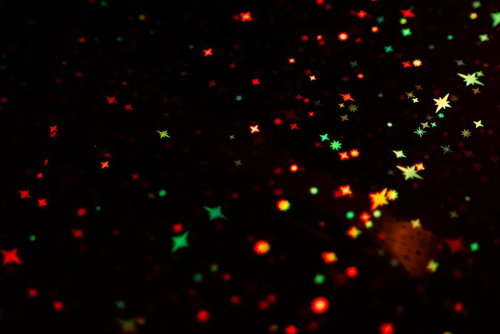 赤と緑の星形エフェクトが散らばるホログラム背景