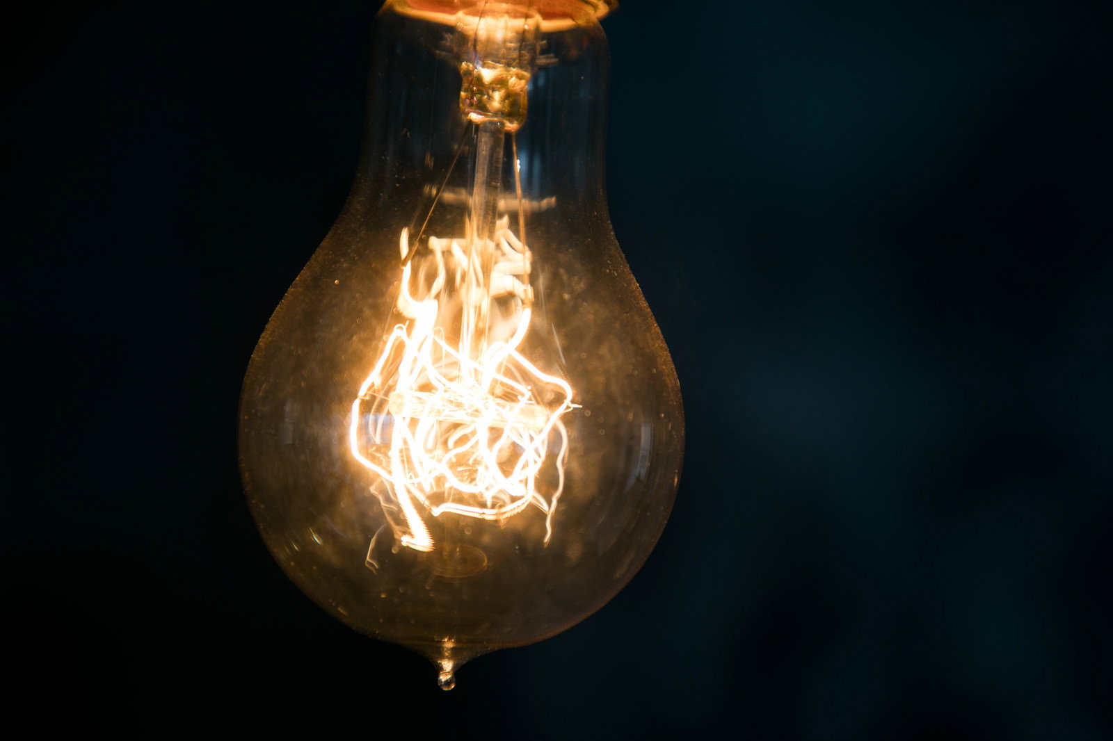 暗い背景に浮かぶフィラメント電球