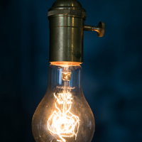 暖かいオレンジ色に光るフィラメントタイプのエジソン電球の写真