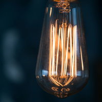 縦に伸びるフィラメント電球の暖かいオレンジ色の明かりの写真