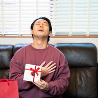 バレンタインデーにもらった本命チョコに胸キュン、ソファで満足げな男性の写真