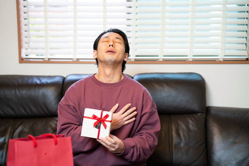 バレンタインデーにもらった本命チョコに胸キュン、ソファで満足げな男性