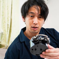 目覚まし時計の時間が止まってた、驚く男性の写真