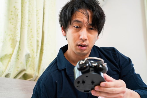 目覚まし時計の時間が止まってた、驚く男性