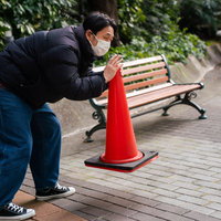 漫画家に三角コーンを届ける男性の写真