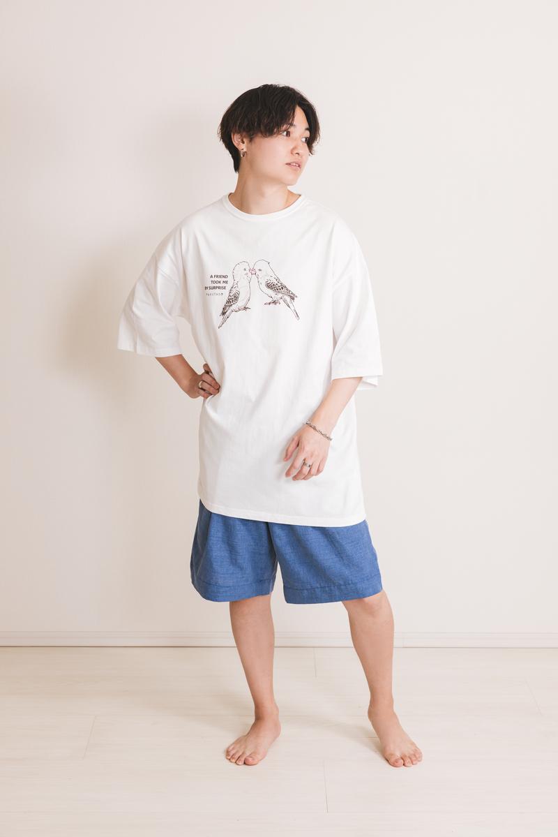 白Tシャツを着た細身の男性が横向きに立ち、カジュアルなポージングをしている［モデル：SHUN］