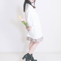 白いTシャツとチェックスカートでチューリップを持った女性の写真