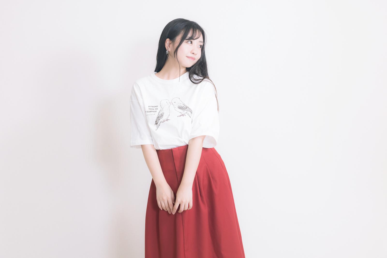 白いTシャツと赤いロングスカートを着た女性が白い背景でポージング［モデル：河村友歌］