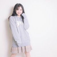 インコのパーカーを着てご満悦の若い女性のポートレートの写真