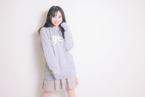 インコのパーカーを着てご満悦の若い女性のポートレート