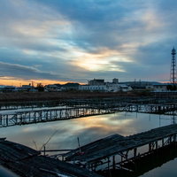 水面に映り込む夕暮れ空と雲の風景の写真