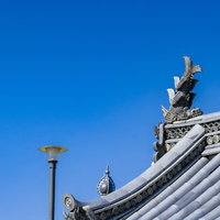 瓦屋根の上に設置された伝統的な鯱（しゃちほこ）の写真