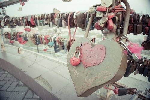 橋に取り付けられた赤いハート形の南京錠、愛の誓いを示すペアロック