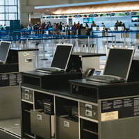 空港のチェックインカウンターで手続きを行う旅客たちの写真