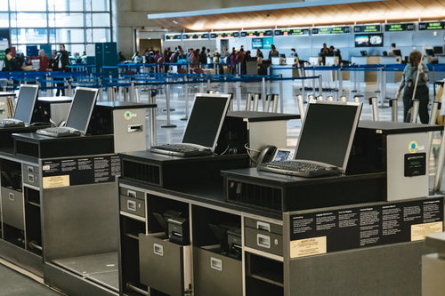 空港のチェックインカウンターで手続きを行う旅客たち