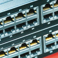 データセンターに整然と並ぶ黄色いケーブル接続のLANポートの写真