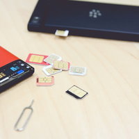 赤と黒のスマートフォンとSIM交換の準備の写真
