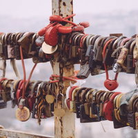 手すりに大量に取り付けられたカラフルな南京錠の写真