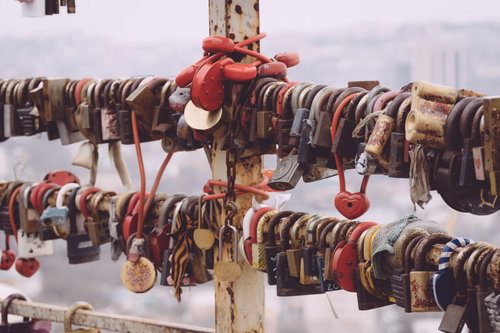 手すりに大量に取り付けられたカラフルな南京錠