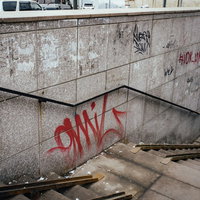 赤い落書きが多い不気味な地下への階段通路の写真