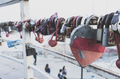 手すりに取り付けられたハート型の南京錠と赤い布