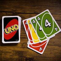 同じ数字を場に出すハウスルール、木目テーブルに広がるUNOカードの写真