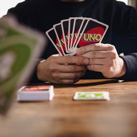 UNOカードゲームをプレイする男性の写真