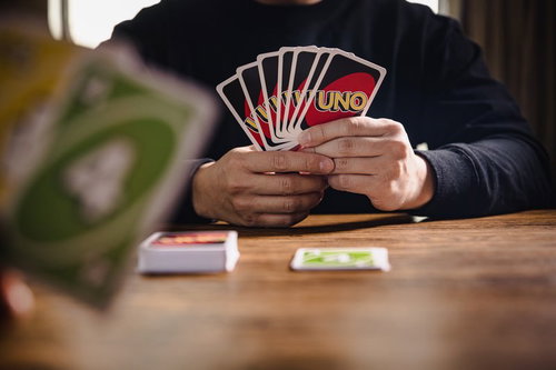 UNOのカードを扇状に広げてプレイする手元