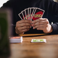7枚の手札を扇状に持つUNOの対戦相手のカードゲームの写真