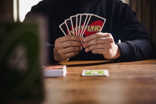 7枚の手札を扇状に持つUNOの対戦相手のカードゲーム