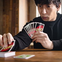 山札からカードをめくる緊張の一瞬、男性プレイヤーの真剣な表情の写真