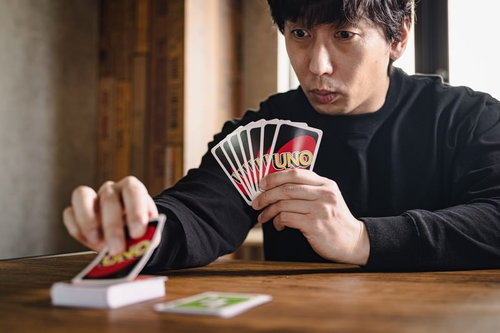 山札からカードをめくる緊張の一瞬、男性プレイヤーの真剣な表情