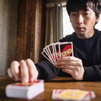 生まれつきポーカーフェイスのプレイヤー、UNOで真顔の男性の写真
